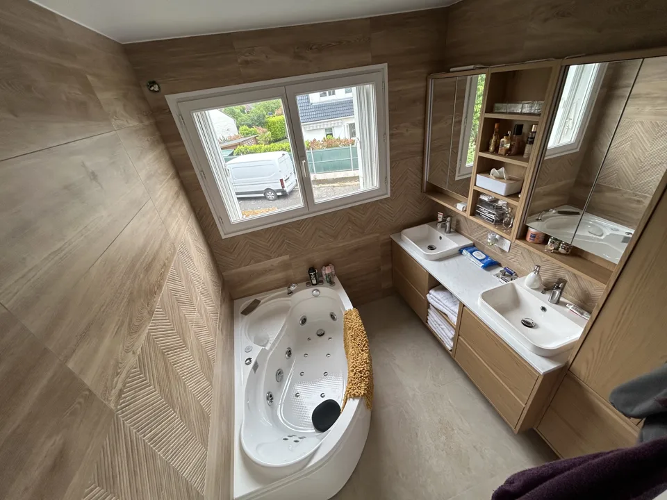 Salle de bain rénovée, carrelage effet bois et baignoire balnéo
