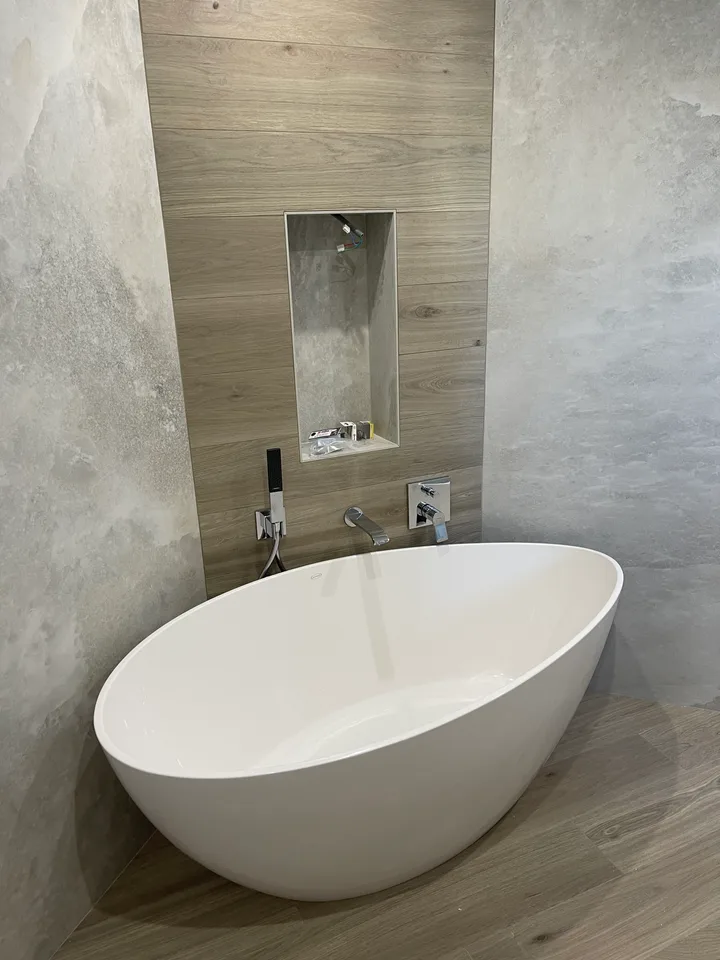 Baignoire îlot devant un mur effet bois