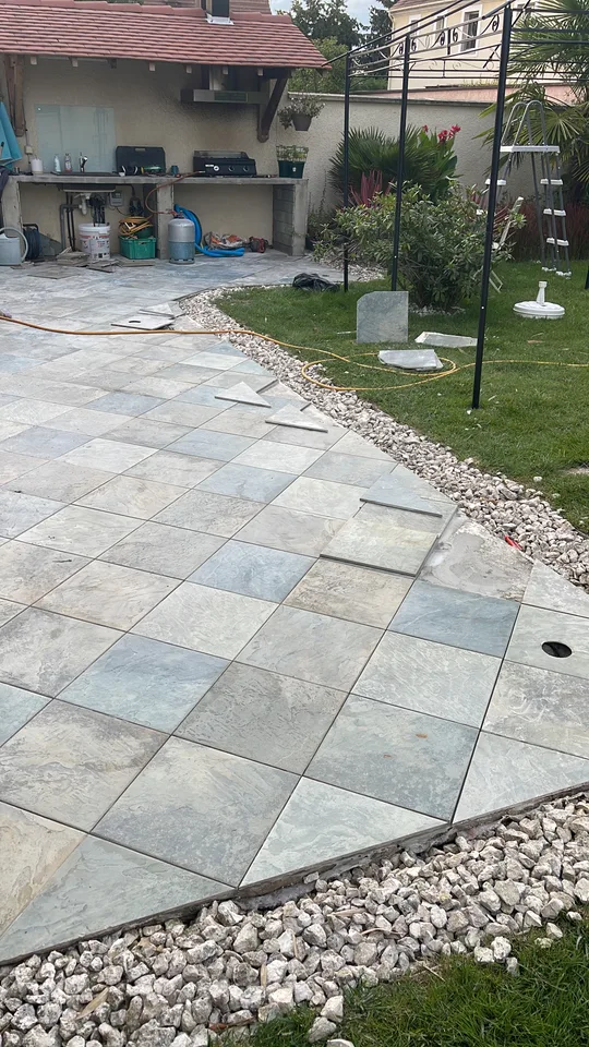 Terrasse terminée, carrelage effet pierre et bordure de galets