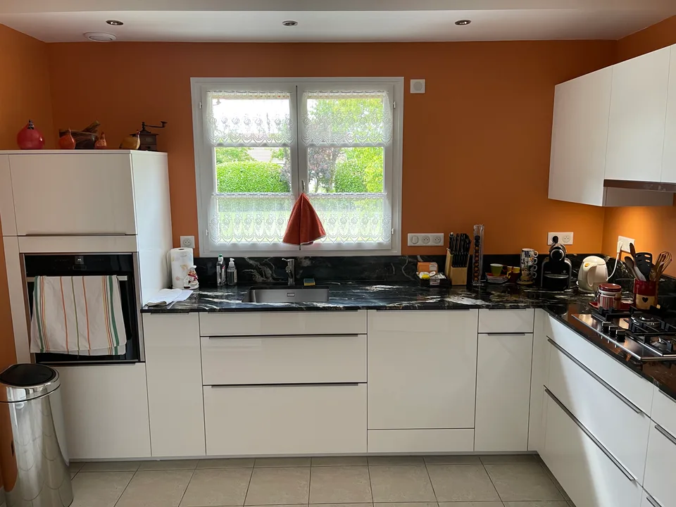 Cuisine en U blanche sous la fenêtre